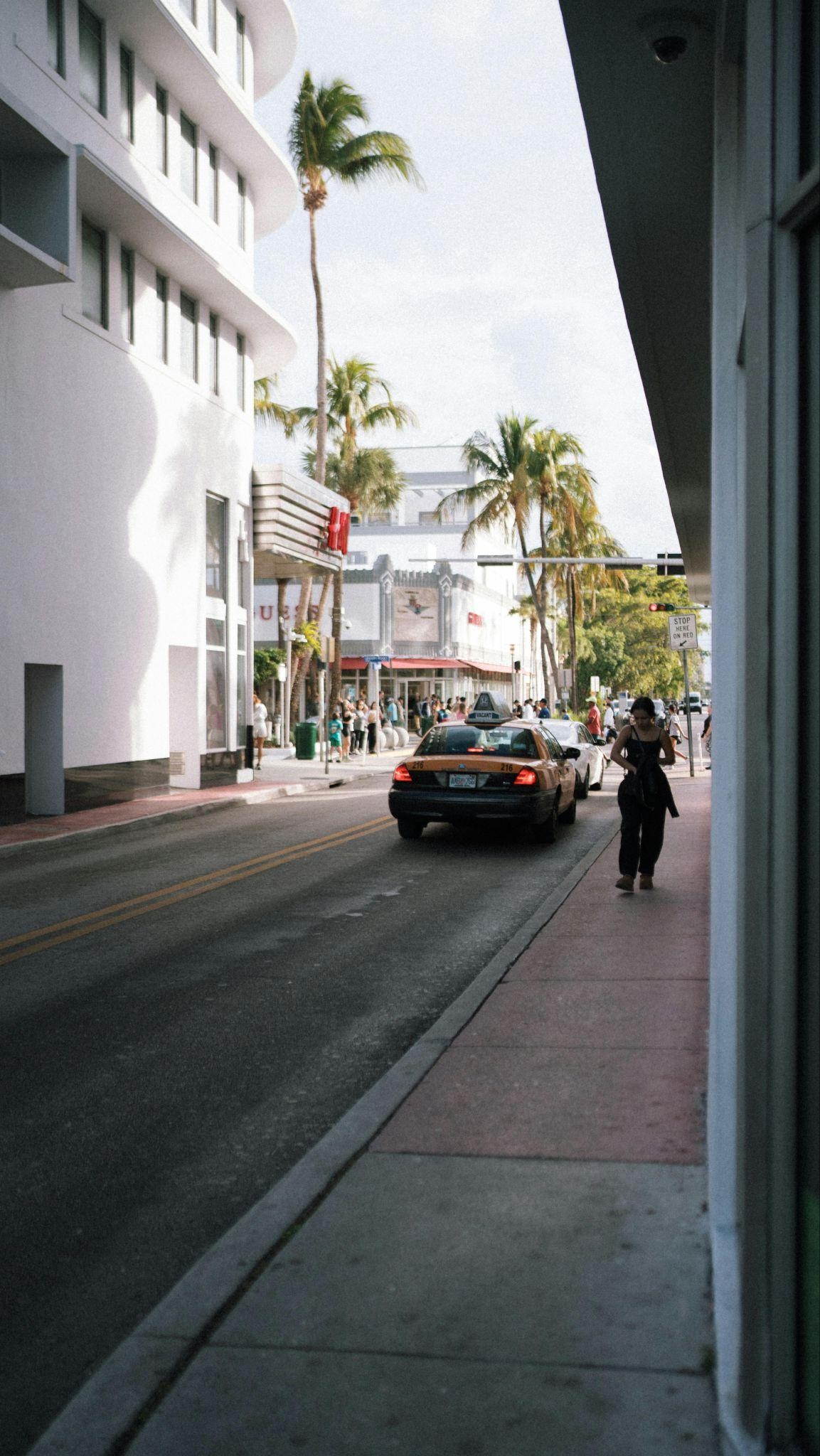 A yellow taxi driving by on a busy road